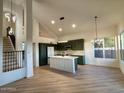Modern kitchen with dark green cabinets, white quartz countertops, and stainless steel appliances at 6891 W Via Del Sol Dr, Glendale, AZ 85310
