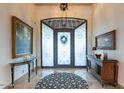 Elegant foyer with decorative rug, art, and frosted-glass door with wrought iron detailing and high ceilings at 10742 E Greythorn Dr, Scottsdale, AZ 85262