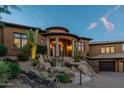 Charming home featuring a grand entrance with elegant columns and desert landscaping at 10742 E Greythorn Dr, Scottsdale, AZ 85262