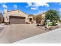 A single-story house showcases a two-car garage, desert landscaping, and well-maintained surroundings at 26822 W Oraibi Dr, Buckeye, AZ 85396