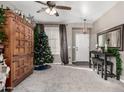 Living room with Christmas tree, wooden cabinet, and gray sofa at 8813 N 112Th Ave, Peoria, AZ 85345