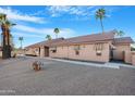 Rear exterior showing the desert landscaping, awning-shaded windows, and tiled roof at 10309 E Twilight Ct, Sun Lakes, AZ 85248
