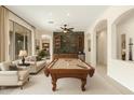 Spacious game room features a pool table, stone accent wall, and built-in bar area for entertaining guests at 9354 E Hillview Cir, Mesa, AZ 85207