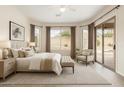 Bright main bedroom featuring ample natural light, a sitting area, and a sliding door for outdoor access at 9354 E Hillview Cir, Mesa, AZ 85207
