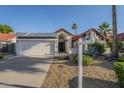 Charming single-story home featuring a well-manicured front yard and a two-car garage at 11085 E Becker E Ln, Scottsdale, AZ 85259