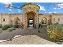 Inviting home featuring a stone archway entrance with a tiled path through desert landscaping at 13141 E Cibola Rd, Scottsdale, AZ 85259