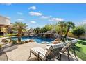 Resort-style pool features a rock waterfall, palm trees, and a nearby putting green for recreation at 13141 E Cibola Rd, Scottsdale, AZ 85259