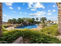Beautiful pool area with a rock waterfall, lush greenery, and comfortable lounge chairs at 13141 E Cibola Rd, Scottsdale, AZ 85259
