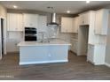 Modern kitchen featuring white cabinets, a center island, and tile backsplash at 4924 W Beryl Ave, Glendale, AZ 85302