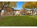 Stone and stucco house with autumn trees and landscaping at 24002 S 201St Ct, Queen Creek, AZ 85142