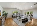Bright living room featuring a vaulted ceiling, parquet floors, large windows, and neutral decor at 4531 E Quartz Mountain Rd, Paradise Valley, AZ 85253