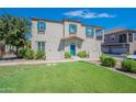 Two-story home with teal door, landscaping, and attached garage at 4718 E Thunderheart Trl # 103, Gilbert, AZ 85297