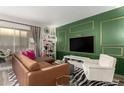 Living room with green feature wall, sectional sofa and wood floors at 7970 E Camelback Rd # 101, Scottsdale, AZ 85251