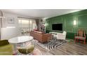 Living room with a green accent wall, comfortable seating and a large TV at 7970 E Camelback Rd # 101, Scottsdale, AZ 85251