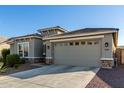 Two-car garage and neutral-toned exterior with desert landscaping at 18865 W Mescal St, Surprise, AZ 85388