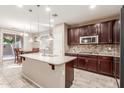 Spacious kitchen featuring granite countertops and dark wood cabinets at 314 N 79Th Pl, Mesa, AZ 85207