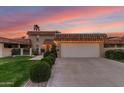 Inviting home showcasing a two-car garage, mature landscaping and a charming tile roof at 9734 N 105Th Dr, Sun City, AZ 85351