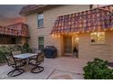 Outdoor patio featuring a dining table with seating for four, a grill, and lush landscaping at 9734 N 105Th Dr, Sun City, AZ 85351