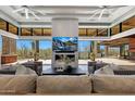 Bright living room with fireplace, TV, modern decor, and open access to the outdoor living space at 10878 E Sundance Trl, Scottsdale, AZ 85262