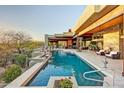 Inviting backyard pool featuring waterfall features, desert landscaping, and seamless indoor-outdoor living at 10878 E Sundance Trl, Scottsdale, AZ 85262