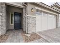 Beautiful front exterior features stone accents, a dark front door and gray brick pavers at 12527 W Sierra Vista Ct, Glendale, AZ 85307