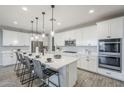 Spacious eat-in kitchen features a central island, stainless appliances, and white cabinets at 12527 W Sierra Vista Ct, Glendale, AZ 85307