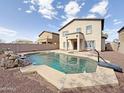 Backyard pool features patio, rock waterfall, privacy fence, and a basketball hoop at 13779 W Mauna Loa Ln, Surprise, AZ 85379