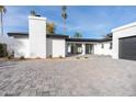 Modern home exterior with white brick and a black garage door at 342 E Orangewood Ave, Phoenix, AZ 85020