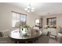 An inviting dining room features a round wooden table set for a meal, complemented by stylish furnishings and natural light at 8808 W State Ave, Glendale, AZ 85305