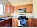 Bright kitchen featuring stainless steel appliances, wooden cabinets, and light countertops at 8808 W State Ave, Glendale, AZ 85305