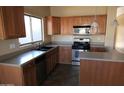 Spacious kitchen with wood cabinets, stainless steel appliances, and an island at 8808 W State Ave, Glendale, AZ 85305