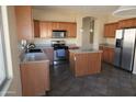 Kitchen features an island, stainless steel appliances, and ample wood cabinets at 8808 W State Ave, Glendale, AZ 85305