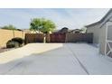 Large backyard with a paved patio area and gated access to the rear of the property at 1228 N 102Nd St, Mesa, AZ 85207