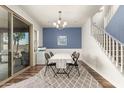 Dining area with table, chandelier, and a sliding door to the patio, adjacent to the stairway at 19544 W Lincoln St, Buckeye, AZ 85326