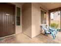 Front porch with two teal chairs and a dark brown door at 19544 W Lincoln St, Buckeye, AZ 85326