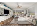 Spacious living room featuring wood floors, a large sectional sofa, and custom built-in shelving at 19544 W Lincoln St, Buckeye, AZ 85326