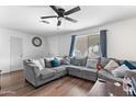 Living room featuring a gray sectional sofa and ceiling fan at 5546 W Encanto Blvd, Phoenix, AZ 85035