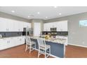 Modern kitchen with white cabinets, granite counters and island at 7873 W Fetlock Trl, Peoria, AZ 85383