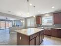 Open-concept kitchen with an island and views into the adjacent living area at 9438 W Georgia Ave, Glendale, AZ 85305