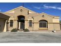 Tan colored house with decorative accents, arched entryway, and attached garage at 10040 E Grandview St, Mesa, AZ 85207