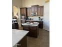 Island kitchen with dark wood cabinets, white countertops, and stainless steel appliances at 10040 E Grandview St, Mesa, AZ 85207