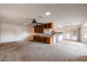 Open-concept living space with built-in cabinetry, a ceiling fan, and sliding glass doors to the outside at 13359 W Ballad Dr, Sun City West, AZ 85375