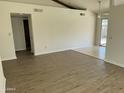 Open-concept living room featuring wood floors and access to a tiled kitchen and outdoor patio at 1770 E Sandra Ter, Phoenix, AZ 85022