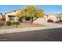 House exterior showcasing a front yard with a tree and drought-tolerant plants at 10051 S 184Th Dr, Goodyear, AZ 85338