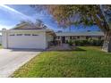 Ranch style home with attached garage and well-manicured lawn at 10113 W Kingswood Cir, Sun City, AZ 85351