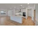 Bright kitchen with a central island, white cabinets, and stainless steel appliances at 14778 W Tether Trl, Surprise, AZ 85387