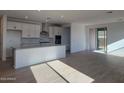 Bright kitchen featuring white cabinets, an island, and tile flooring at 33333 N 132Nd Dr, Peoria, AZ 85383