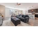 Open living room with grey sofas, a coffee table, and wood-look floors at 7067 W Maya Way, Peoria, AZ 85383