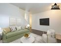 Inviting living room with a comfortable green sofa, a white chair, and stylish decor at 9202 W Cambridge Ave, Phoenix, AZ 85037