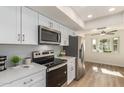 Modern kitchen featuring white cabinets, stainless steel appliances, and a spacious layout at 10018 W Burns Dr, Sun City, AZ 85351